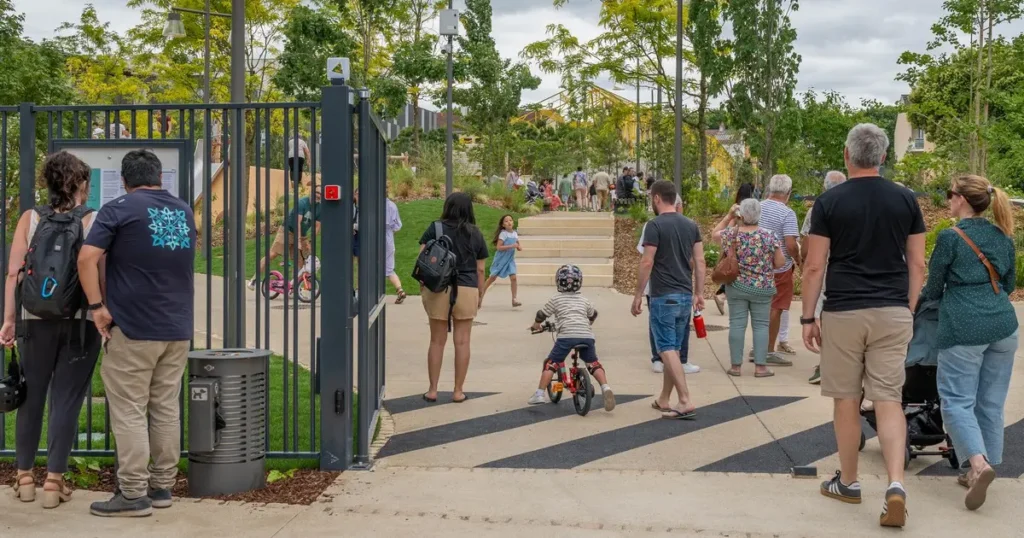 personnes adultes et enfants à l'entrée d'un parc de verdure